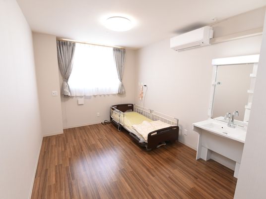 居室は十分な広さが確保されている個室。エアコンが設置されているので快適である。白い壁とフローリングになっている。