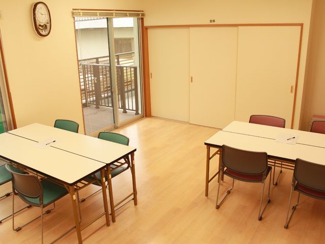 多目的室のシンプルな様子 共有スペース 広々とした空間の多目的室で、日当たりが良く、車椅子の方もスムーズに動ける設計です。ここで様々なレクリエーションや活動が行われます。
