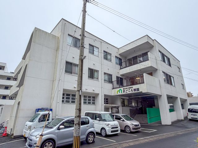 白い建物の外観 外観 しっかりとした建物の前には駐車スペースがあり、アクセスしやすさが魅力です。施設の入り口は明確で、訪問客にも分かりやすく設計されています。