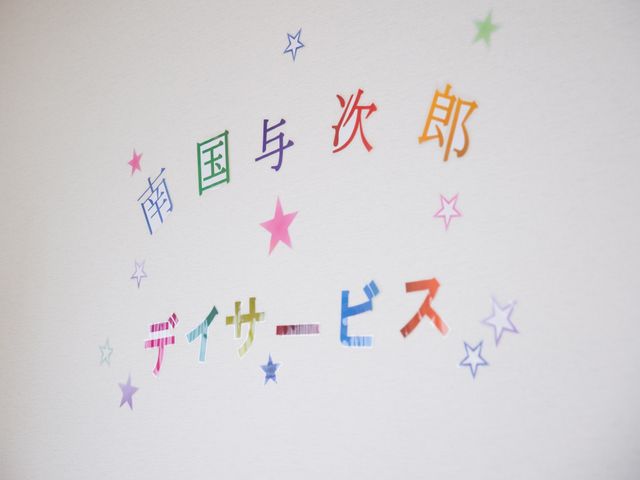 カラフルな掲示物 ロゴ 壁に貼られたカラフルな文字が、訪れた方々に暖かいメッセージを伝えています。色とりどりの星形が周りを飾り、活気あふれる環境を作り出しています。