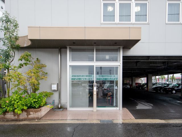 施設の入り口と案内表示 外観 清潔感のあるエントランスには、来訪者を迎える案内板が設置されており、親しみやすい雰囲気が漂っています。