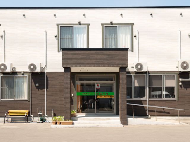 施設の明るいエントランス 外観 ゆったりとしたベンチが設置されたエントランスは、来訪者を温かく迎え入れます。バリアフリー設計で、どなたでも安心してご利用いただけます。