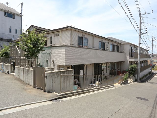 明るい外観の建物エントランス 外観 整備された門と外観が目を引く建物です。清潔感と静けさが感じられるエントランス周辺をご覧ください。