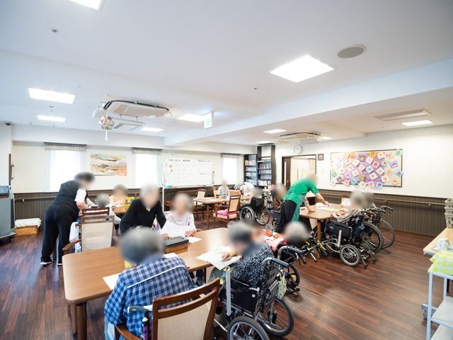 利用者様が集う活動室 食堂 賑やかな雰囲気の中、利用者様が共に過ごす食堂。フロアスタッフが丁寧に対応しており、和気あいあいとしたコミュニケーションが生まれています。