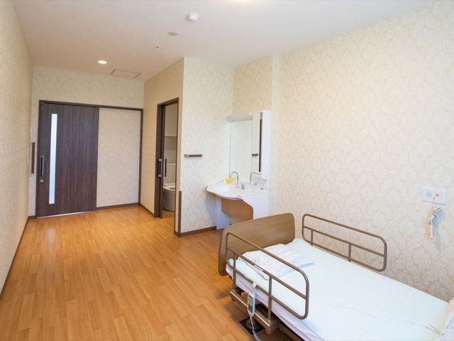 広々とした明るい居室 居室 ゆとりある居室には、必要な家具が整い、安心して生活が始められます。ベッドの傍らには、利用者の快適さを考えた洗面台が備え付けられています。