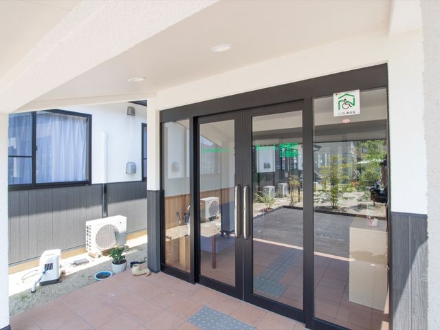 エントランスの外からの眺め 玄関 採光を取り入れた明るいエントランスです。ゆったりとした出入りが可能で、外には緑豊かな中庭が広がっています。