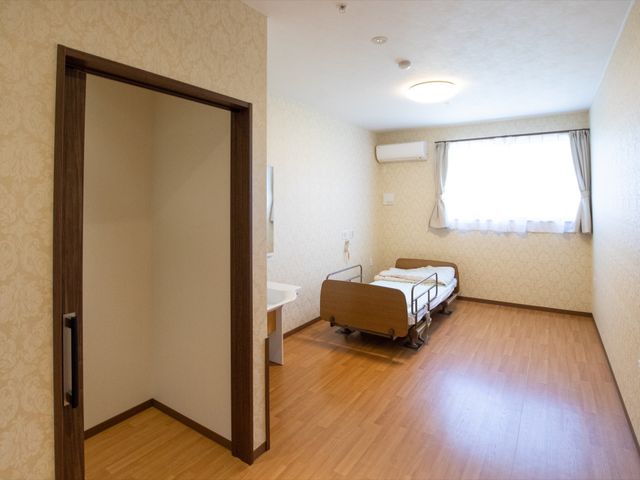 快適な居室の様子 居室 落ち着いた色合いの居室は、広々としており、心地よい日常生活を送ることができそうです。窓からの自然光が室内を明るく照らしています。