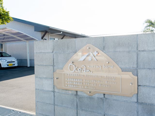 看板とその前景 看板 清潔感のある壁に設置された看板が、ゆとりある環境でのケアを印象づけます。興味を持たれた方はぜひ見学にいらしてください。