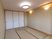サムネイル 施設の写真 押し入れが備えつけられている畳が敷かれた部屋。壁には、デザイン性のある照明やコンセントが設置されている。