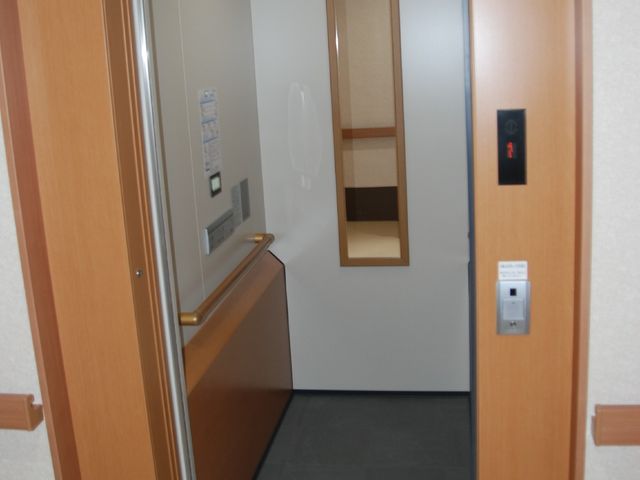 木目調のエレベーター エレベーター バリアフリー設計の広々としたエレベーターは、移動のしやすさを考慮しています。明るく清潔感のある空間が、心地よい移動時間を演出しています。