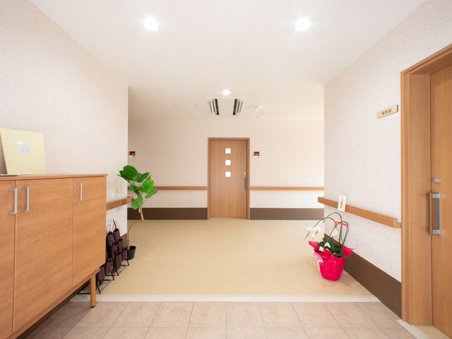 清潔感のある明るい廊下 玄関 明るく広々とした廊下は、落ち着いた色合いで統一されており、訪れる方々を温かく迎えます。ゆったりとした空間でのお仕事をお求めですか。