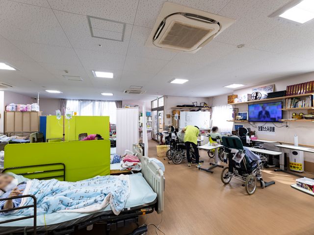 快適な多目的室の光景 共有スペース ゆったりとしたスペースのある居心地の良い空間です。利用者の方々がリラックスして過ごされており、働く環境としても配慮された設計になっています。