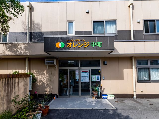 オレンジ色ロゴの入口 温かみのあるオレンジ色のロゴが目を引く入口です。周囲の緑や植物の配置も、訪れた方々への心配りが感じられます。