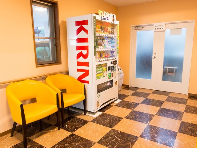 休憩スペースと自動販売機 自動販売機 明るい色彩の椅子が設置された休憩スペースです。自動で飲み物を購入でき、ちょっとした息抜きに最適です。
