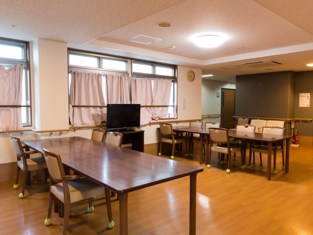共有スペースの居心地の良さ 共用スペース 木製のテーブルと椅子が配置された共有ダイニングです。居心地の良い明るい空間で、コミュニケーションが育まれます。
