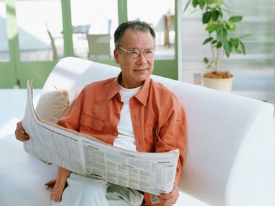 新聞を読む男性とソファ
