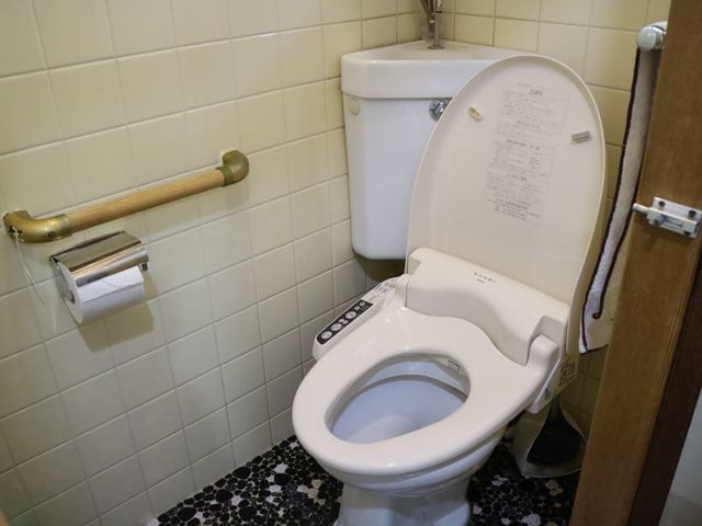 手すり付きトイレ設備 トイレ 手すりが設置された清潔なトイレで、安心してご利用いただける設計となっています。安全性と快適性を兼ね備えた空間です。