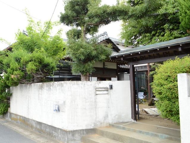 緑に囲まれた一軒家外観 玄関 自然に囲まれた環境で、居心地の良い時間を過ごすことができます。木々に覆われた門から、穏やかな雰囲気がただよっています。