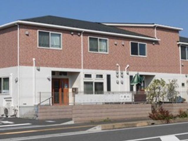 施設の外観 外観   赤茶色の外壁が印象的な2階建ての建物です。道路沿いにあり、出入口まわりがすっきりした外観です。