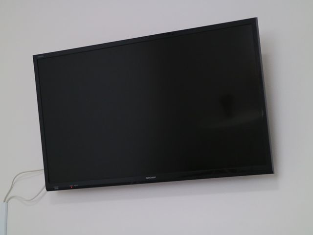 壁掛けの液晶テレビ テレビ 落ち着いた雰囲気のリビングで、壁に設置された大型テレビが居住者の楽しみの一つです。