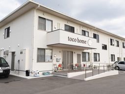 白い建物とロゴのエントランス
