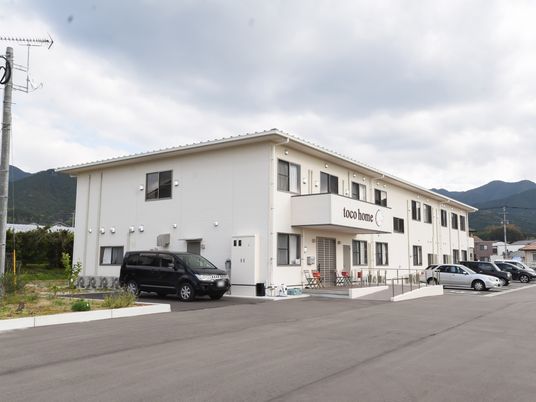 白い壁の建物と駐車場