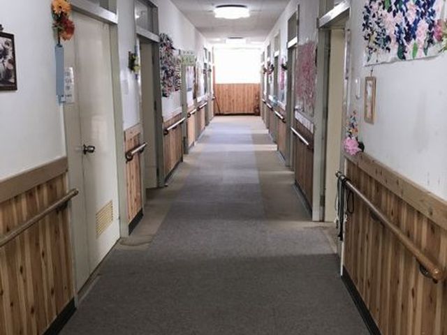 手すり付きの廊下 廊下   両側に手すりがあり、歩行しやすそうな通路です。壁面の飾りがあり、明るく整った印象です。