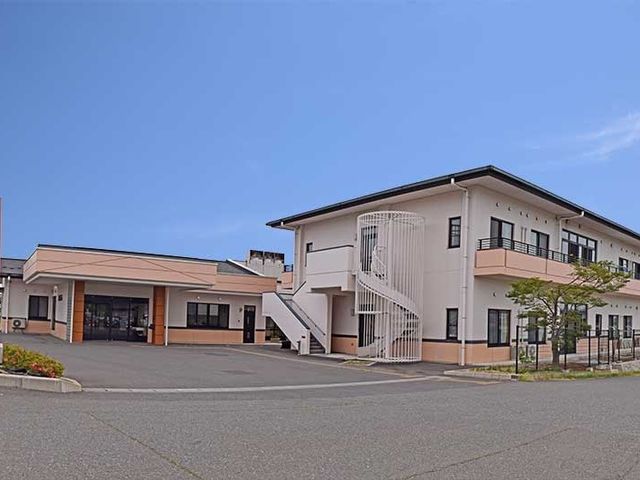 建物外観 外観   落ち着いた色合いの建物で、正面に広い駐車スペースが見えます。外階段もあり、出入りの動線を確認しやすい外観です。