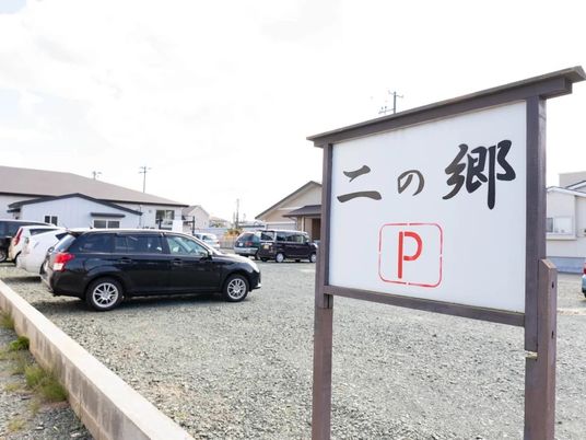 施設看板と駐車場の外観  