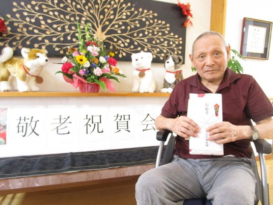 車椅子の男性と飾り棚