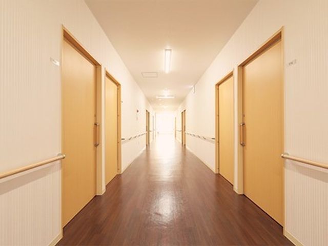 清潔な廊下の風景 廊下 落ち着いた色合いの廊下は、清潔感があり過ごしやすい設計です。床は光沢があり、手すりも設置されており安心です。