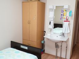 居室の洗面台とベッド