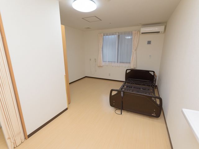 介護用ベッドのある居室 居室 機能的なレイアウトの個室。日々のケアに集中できる落ち着いた作業環境を提供します。