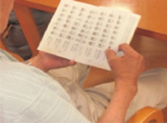 椅子で本を読む人の手元