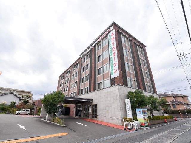 多階層の建物の外観 外観 広々とした入口が迎える、落ち着いた色合いの建物です。整備されたアクセスで、働く環境も快適に感じられます。