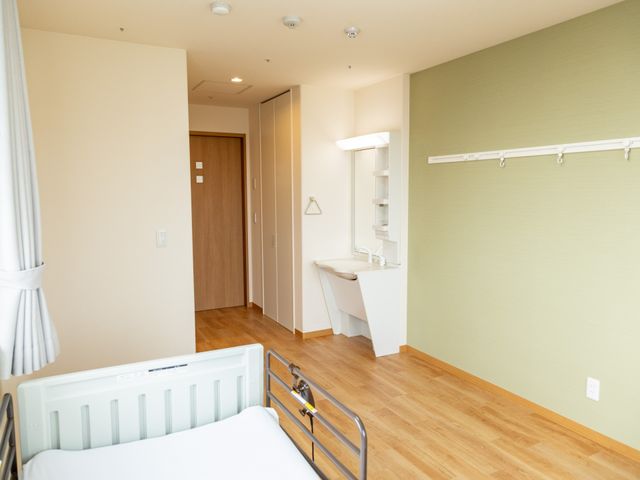 居室の清潔な空間 居室 ゆとりある居室では、やわらかな光が差し込み、落ち着いた色合いで心地よい時間を過ごせます。