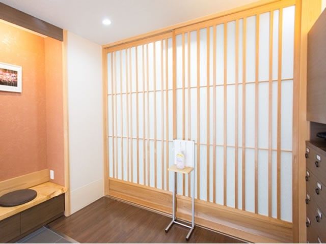 和室のシンプルな壁 環境 落ち着いた色合いの和室スペースです。日々の業務に役立つ椅子と設備が整っており、心地よい環境が提供されています。