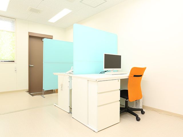 清潔なオフィススペース 訪問介護事業所 整理されたデスクと鮮やかな椅子が特徴の作業空間です。明るく穏やかな雰囲気で業務に取り組めます。