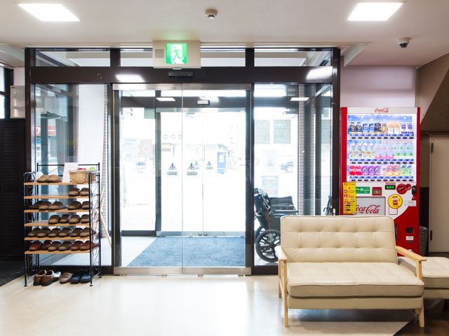 エントランスと自動販売機 エントランス 広々とした明るい入り口には、待ち時間にリラックスできるソファが配されています。訪れる方々を温かく迎える快適な空間を体感いただけます。