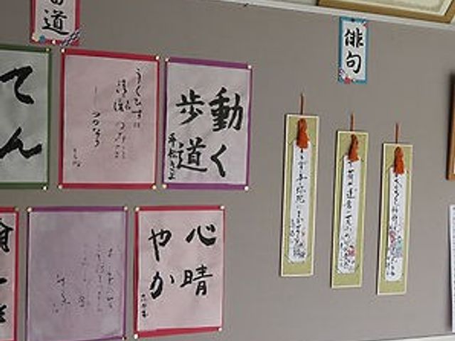 掲示物の壁 掲示物 多彩な作品が掲示された壁です。書道や俳句が飾られ、文化活動が盛んな印象を受けます。
