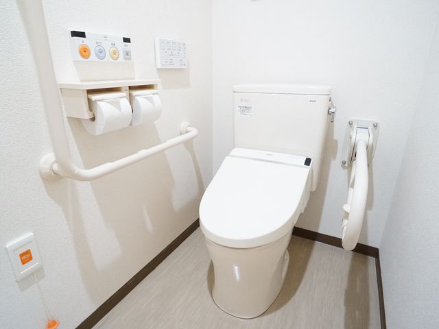 手すり付きのトイレ トイレ 使いやすい工夫がされているトイレです。手すりが設置されており、どなたでも利用しやすい構造になっています。