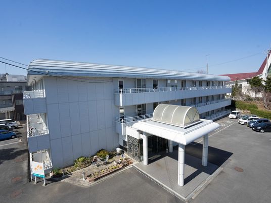 白い建物の外観とエントランス