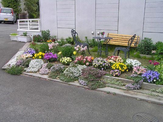 色とりどりの花とベンチ