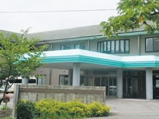 緑に囲まれた建物の外観  