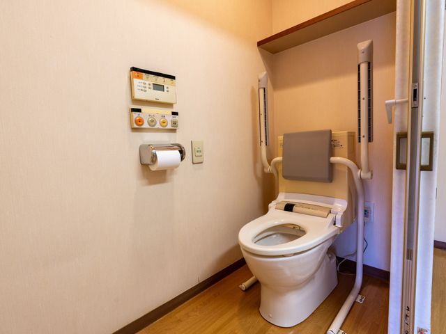 手すり付きトイレの内観 トイレ 手すりが備えられた清潔なトイレで、利用者の方の安全と利便性を考えた設計です。