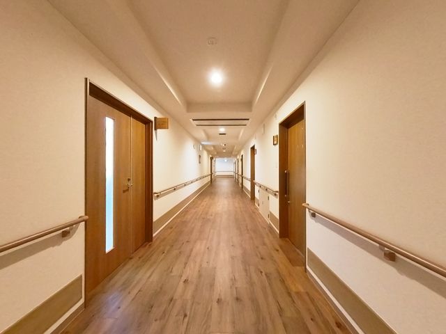 通路の廊下 廊下 明るい照明と手すりが備わった安全な通路です。車椅子の利用者も安心して通行できます。