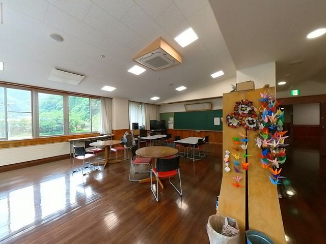 明るい広々とした共有スペース 多目的室 ゆったりとした室内には、テーブルと椅子が配置され、窓からは自然光が差し込んでいます。ここで様々な活動や交流が楽しめる空間です。