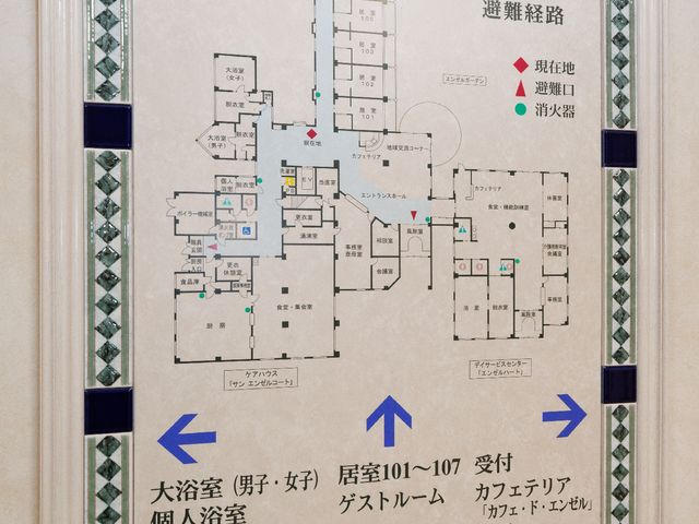 案内図が掲示された廊下 避難経路 入り口近くの壁面には、施設の案内図が明瞭に表示されており、配置を一目で把握できます。職員や利用者の方々が迷うことなく、日々の活動を行える工夫がされています。