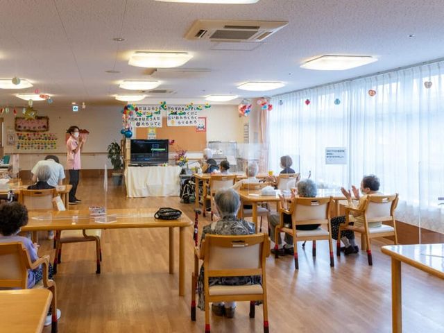 共有スペースの日常風景 ダイニングルーム 広々とした明るいダイニングルームで、利用者同士が穏やかな時間を過ごされています。お食事や交流の場としてご利用いただけます。