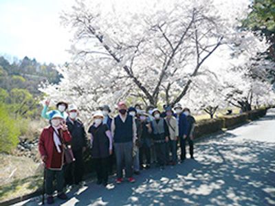 笑顔でお花見する職員と入居者